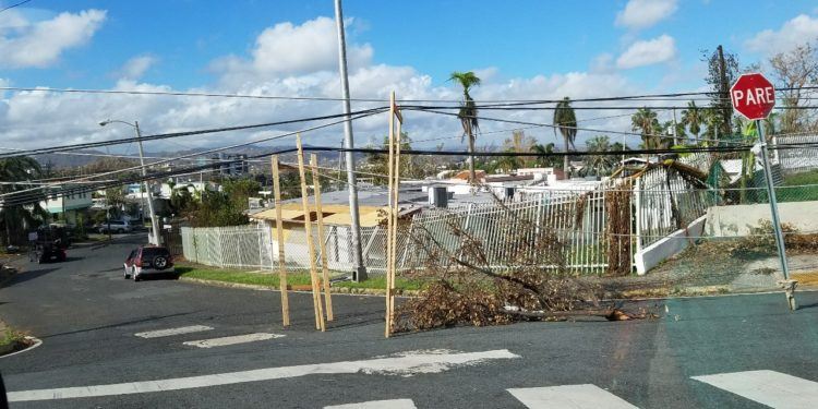 En vez de cortar los cables que yacÃ­an en el pavimento de la entrada a su comunidad, vecinos del sector Alturas de Santa MarÃ­a en San Juan construyeron un armazÃ³n en madera para elevarlos y permitir el trÃ¡fico (foto: TecnÃ©tico)