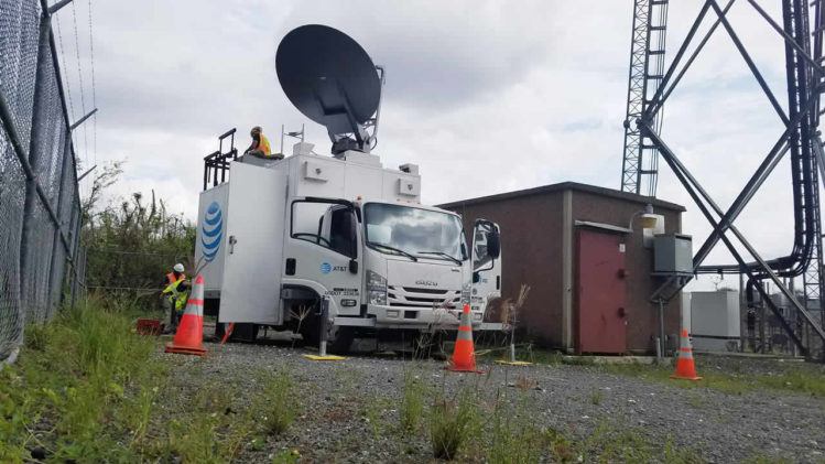 Trabajadores de AT&T enviados por la empresa para ayudar a restaurar las telecomunicaciones instalan una antena satelital sobre ruedas en Vega Baja, Puerto Rico (foto: Tecnético)